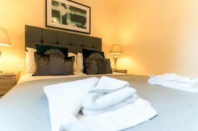 a bed with white towels sitting on top of it at Church View Irene Court Cockermouth in Cockermouth