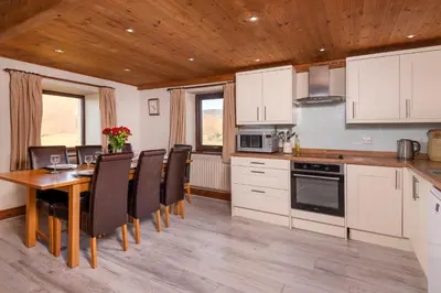 a kitchen with a dining room table and chairs at Saddleback Barn in Penrith