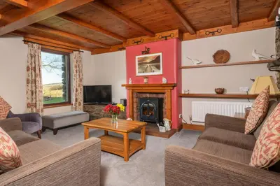 a living room with couches and a fireplace at Stable Barn in Penrith