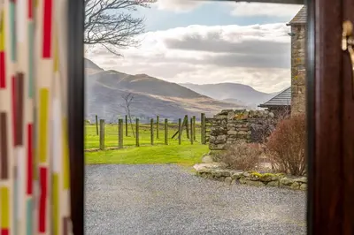 a door leading to a view of a field through a doorway at Grisdale View in Penrith