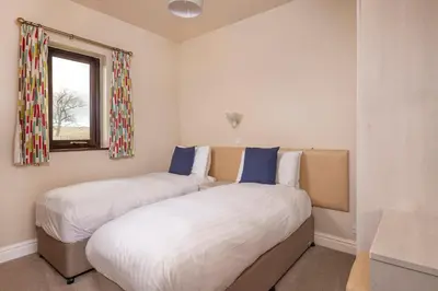 two twin beds in a room with a window at Howe Top in Mungrisdale