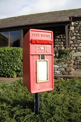 a red post office sign in front of a building at Howe Top in Mungrisdale