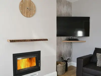 a living room with a fireplace and a clock at Ancrum House in Gretna Green
