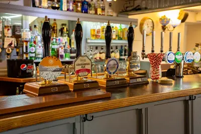 a bar with bottles of alcohol on a counter at Royal Hotel in Dockray