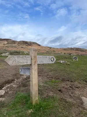 a sign in a field with animals in the background at Royal Hotel in Dockray