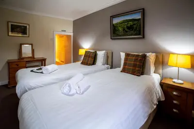 two beds in a hotel room with white sheets at Royal Hotel in Dockray