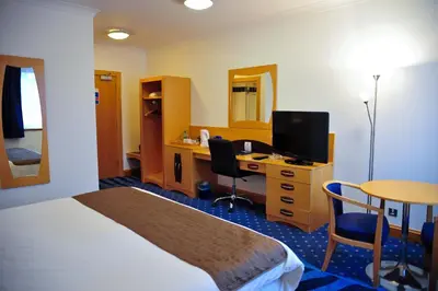a hotel room with a bed and a desk with a computer at The Park Hotel in Kilmarnock