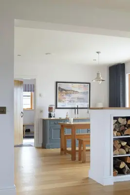 a kitchen with a table and a fireplace at Airds Bay Luxury Beach House in Gatehouse of Fleet