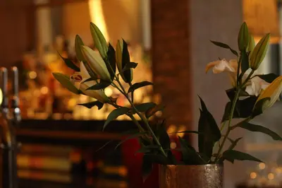a vase with flowers in it sitting on a table at Riverside Lodge Hotel in Irvine