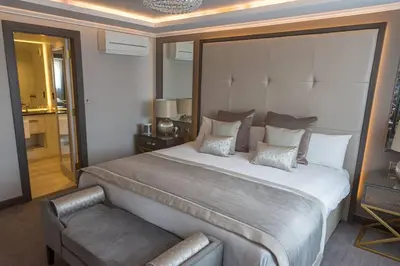 a bedroom with a large bed and a chair at Riverside Lodge Hotel in Irvine