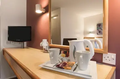 a counter with two cups and a tv in a room at Days Inn Hotel Gretna Green in Gretna Green