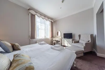 a bedroom with a large white bed and a chair at Tinto Hotel in Symington