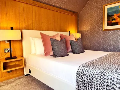 a bedroom with a large white bed with pillows at The Gailes Hotel & Spa in Irvine