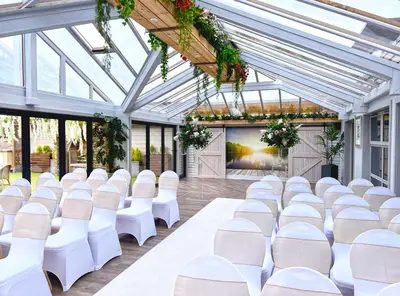 a wedding hall with white chairs and a large screen at The Gailes Hotel & Spa in Irvine