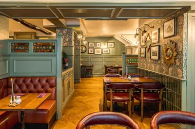 a restaurant with tables and chairs in a room at The Kings Arms Hotel in Keswick