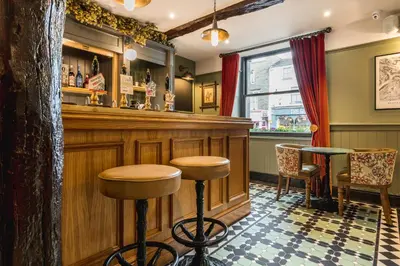 a bar at a pub with two stools at The Kings Arms Hotel in Keswick