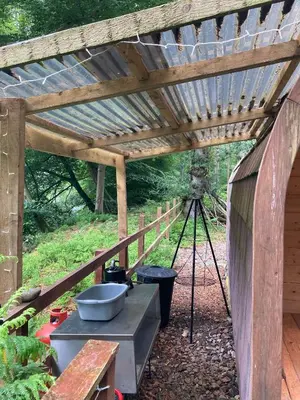 a wooden pergola with a camera under it at Broomhills Farm River Eco Pods in Carlisle