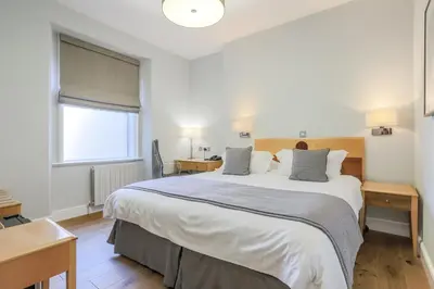 a bedroom with a large bed and a window at Claremont Hotel in Douglas