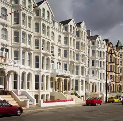 a large white building with cars parked in front of it at The Rutland Hotel in Douglas