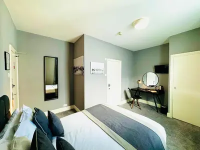 a bedroom with a bed and a desk with a mirror at The Chesterhouse in Douglas