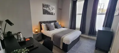 a bedroom with a bed and a desk in a room at The Chesterhouse in Douglas