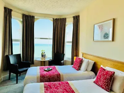 a hotel room with two beds and a window at The Chesterhouse in Douglas