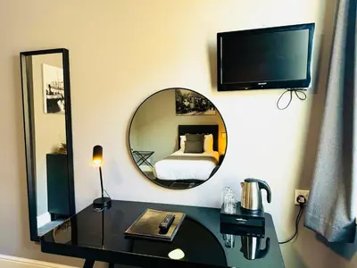 a bedroom with a bed and a mirror and a desk at The Chesterhouse in Douglas