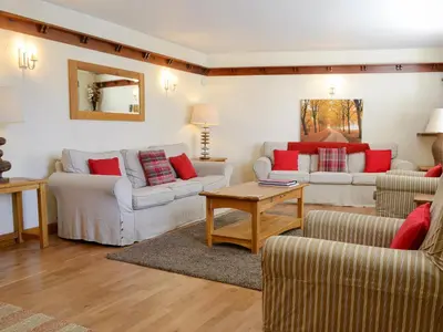 a living room with two couches and a table at Rose Patch Cottage in Keswick