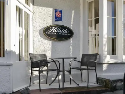 three chairs and a table in front of a building at Skiddaw in Keswick