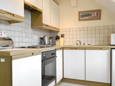 a kitchen with white cabinets and a sink and a dishwasher at Blencathra in Keswick