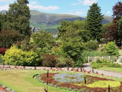 a garden with a flower bed with mountains in the background at Blencathra in Keswick
