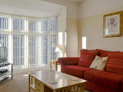 a living room with a red couch and a coffee table at Cat Bells in Keswick