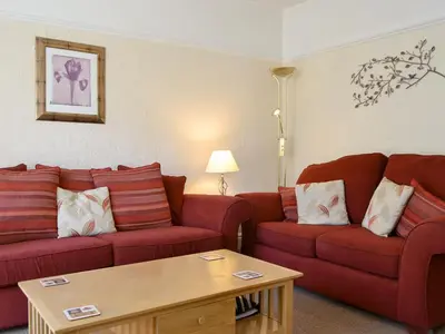 a living room with two red couches and a coffee table at Cat Bells in Keswick