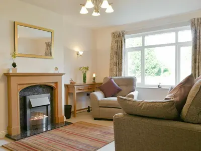 a living room with a fireplace and a couch at Cobble Garth in Keswick