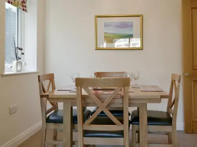 a dining room table with four chairs and a picture on the wall at Cobble Garth in Keswick