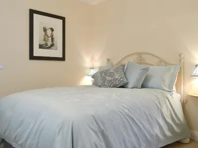 a bedroom with a white bed with blue pillows at Cobble Garth in Keswick
