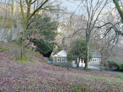 a house in the middle of a forest with trees at The Coach House in Grasmere