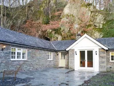 a stone house with a white door at The Coach House in Grasmere