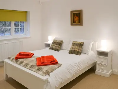 a white bed with two orange towels on it at The Coach House in Grasmere