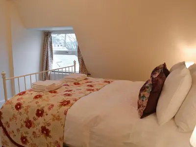 a large bed in a bedroom with a window at Hawthorne House in Bassenthwaite Lake