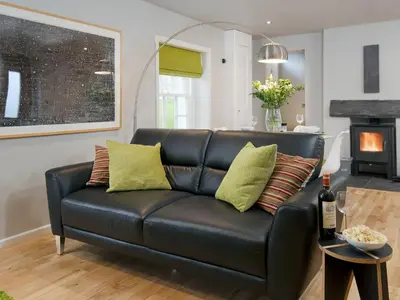 a black leather couch in a living room at Granary in Gatehouse of Fleet