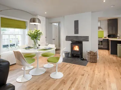 a living room with a table and chairs and a fireplace at Granary in Gatehouse of Fleet