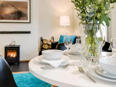 a table with plates and glasses and a vase of flowers at Knocktinkle in Gatehouse of Fleet