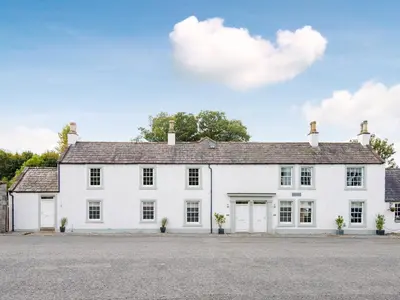a white house with a lot of windows at Knocktinkle in Gatehouse of Fleet