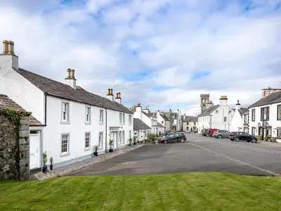 a street in a small town with white houses at Knocktinkle in Gatehouse of Fleet