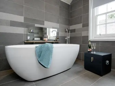 a bathroom with a large white tub and a sink at Knocktinkle in Gatehouse of Fleet