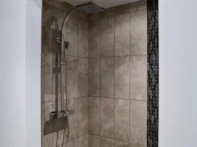 a bathroom with a shower with a glass door at The Wheat Shed in Calthwaite