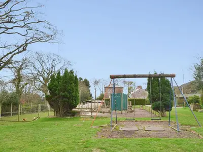 an empty park with a swing set in a field at Blaithwaite House in Blencogo