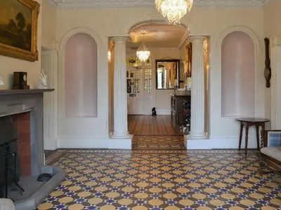 a living room with a fireplace and a chandelier at Blaithwaite House in Blencogo