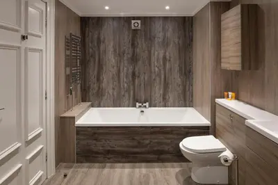 a bathroom with a white tub and a toilet at Fairfield House Hotel in Ayr